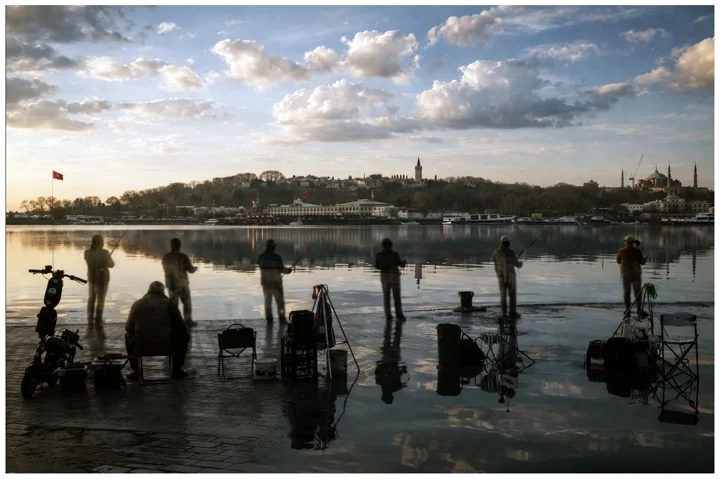 Silhouettes of anglers and reflections beside the Bosphorus
