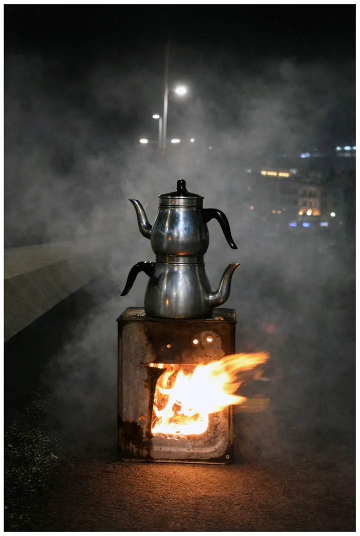 A stacked tea kettle over a small wood fire at night