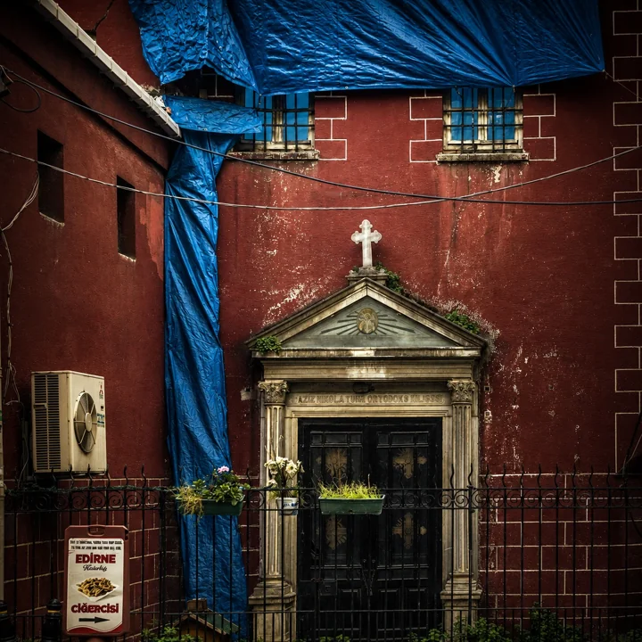 A doorway with a cross set into a red church facade