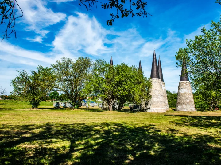 Pointed sculptural spires among trees in a sunlit park
